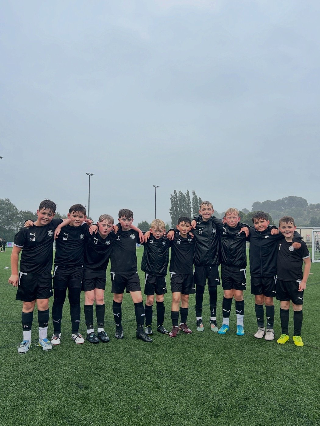 The Under 9s team lined up with their arms around each other